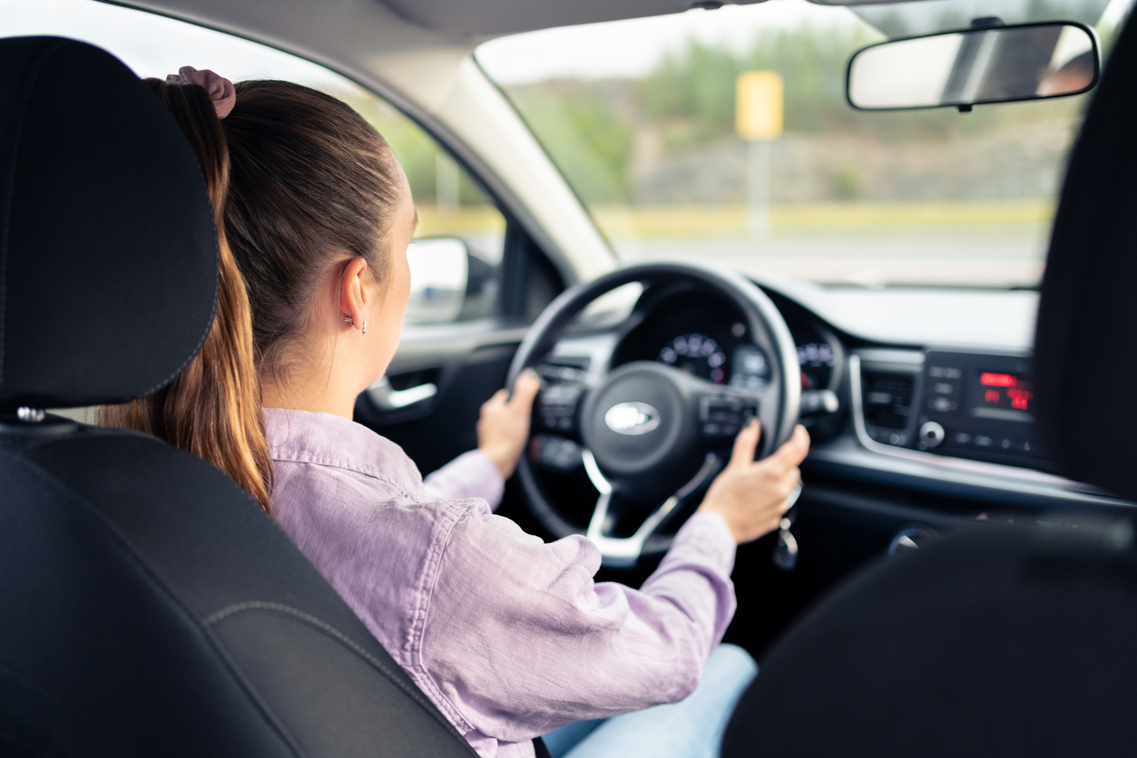 Fahrschülerin übt das sichere Lenken während einer Fahrstunde